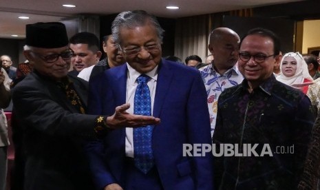 Penasehat Ika Doerdoed ikatan Alumni SMP 5 Jakarta Salamun Sastra (kiri) mempersilahkan Mantan PM Malaysia Mahathir bin Muhammad (tengah) disampingi Ketua Tim Percepatan Pengembangan Pariwisata Halal Kemeterian Pariwisata Republik Indonesia Riyanto Sofyan untuk memasuki ruangan pada acara talkshow bertema “Peluang dan Tantangan Halal Tourism” di Jakarta, Rabu (16/8).