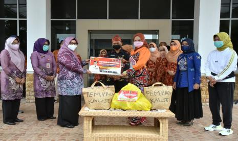 Penasihat  Dharma Wanita Persatuan (DWP) Provinsi Kalimantan Selatan, Hj Raudatul Jannah Sahbirin saat menyalurkan bantuan sosial secara simbolis dalam bentuk barang dan kebutuhan dasar senilai Rp250 juta untuk terdampak banjir di Kalteng. Bantuan  diterimakan Hj Nunu Andriani Edy Pratowo  istri Wakil Gubernur Kateng, di Kantor Dinas Sosial Provinsi Kalteng, Jumat (24/9).