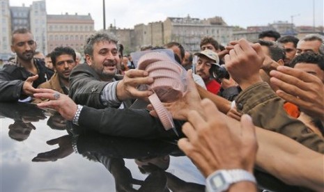 Pencari suaka mengantre sumbangan makanan yang dibagikan dari sebuah mobil di Wuppertal, Jerman, di depan stasiun kereta api Keleti di Budapest, Hungaria, Jumat (4/9).