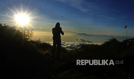 Pendaki menikmati matahari terbit di Sendang Drajat kawasan Puncak Gunung Lawu, Perbatasan Jawa Tengah dan Jawa Timur, Jumat (19/8)