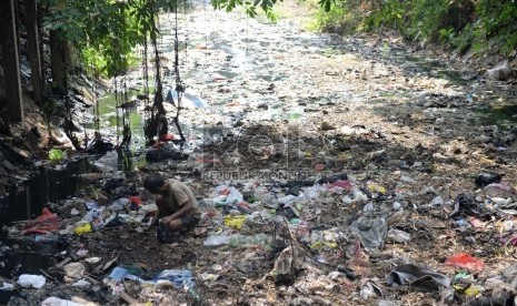 Pendangkalan Sungai. Warga mencari cacing tanah di tumpukan sampah di salah satu sungai yang dangkal di Jakarta, Rabu (8/7).