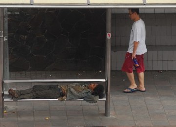 Penderita gangguan jiwa, asyik tertidur di sebuah halte.