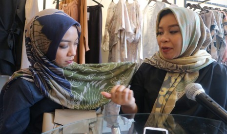 Pendiri Kamiidea, Istafiana Candarini (kanan) menunjukkan motif pattern jilbab koleksi Kamiidea, yang dikenakan pendiri Kamiidea yang lain, Afina Candarini (kiri). 