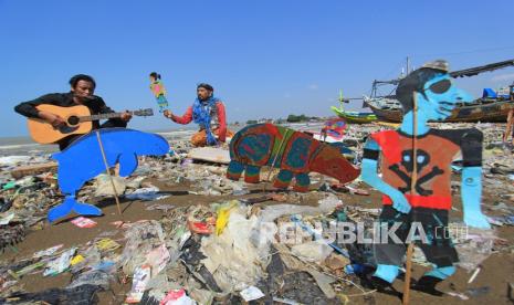 Pendongeng sekaligus seniman tutur Samsudin (kanan) melakukan aksi teatrikal dengan latar belakang tumpukan sampah plastik di Pantai Dadap, Juntinyuat, Indramayu, Jawa Barat, Sabtu (6/5/2021). Aksi teatrikal dalam rangka memperingati Hari Lingkungan Hidup Sedunia itu untuk mengkritisi pengelolaan sampah plastik di Indonesia. 