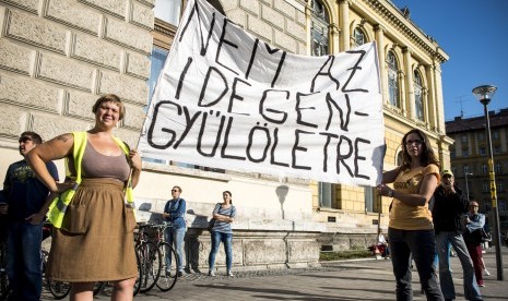 Penduduk Hungaria berunjuk rasa mendukung masuknya migran di stasiun kereta Keleti, di Budapest, (12/9). Mereka membawa spanduk bertuliskan 