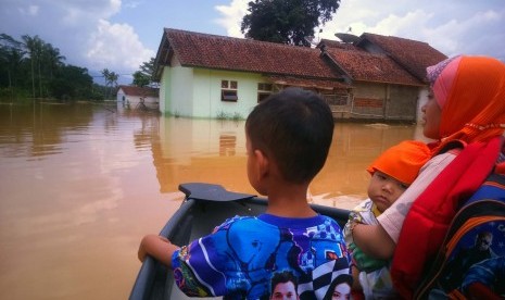 Penduduk mengarungi banjir luapan Sungai Citanduy dan Cikidang, di Desa Tanjungsari, Kecamatan Sukaresik, Kabupaten Tasikmalaya, Kamis (17/3). Banjir mengakibatkan sedikitnya 500 rumah terendam.