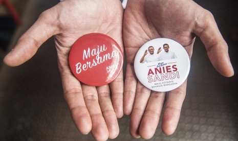 Pendukung calon Gubernur DKI Jakarta Anies Baswedan menunjukan atribut kampanye saat kampanye perdana di pasar Tebet, Jakarta, Jumat (28/10).