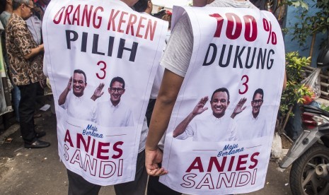 Pendukung Calon Wakil Gubernur DKI Jakarta Sandiaga S. Uno memakai atribut kampanye di Johar Baru, Jakarta, Kamis (10/11). 