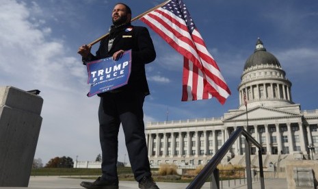  Pendukung Donald Trump, Kern Carlos Huerta, di Utah, (12/11), menanti demonstran yang akan memprotes hasil pilpres AS yang menempatkan Trump sebagai presiden AS.