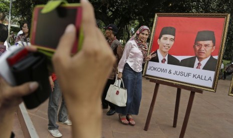 Pendukung Jokowi-JK berfoto dengan gambar pasangan capres nomor urut dua di Jakarta