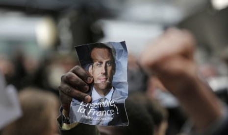  Pendukung kandidat calon presiden Emmanuel Macron mengangkat foto wajah Macron di Paris, Prancis. Jajak pendapat memproyeksikan Macron akan menjadi Presiden Prancis berikutnya, (7/5).