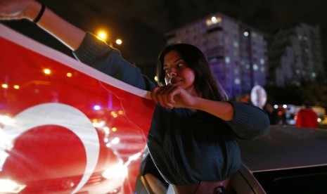 Pendukung kandidat wali kota Istanbul dari partai oposisi Turki Republican People's Party's (CHP), Ekrem Imamoglu, memegang bendera Turki di Istanbul, Senin (6/5).