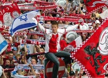 Pendukung klub Ajax mengibarkan bendera Ajax Amsterdam dan bendera Israel.