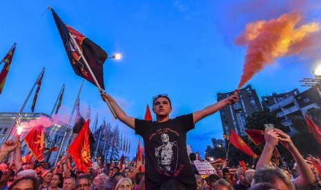 Pendukung partai oposisi VMRO DPMNE mengibarkan bendera dan meneriakkan slogan saat menggelar demonstrasi antipemerintah di depan gedung pemerintahan di Skopje, Macedonia, Sabtu (2/6). 