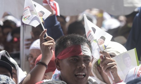 Pendukung pasangan Capres dan Cawapres nomor urut 01, Joko Widodo (Jokowi)-Ma'ruf Amin, berjalan menuju lokasi Konser Putih Bersatu sebagai rangkaian kampanye akbar pasangan capres-cawapres tersebut di Gelora Bung Karno (GBK), Jakarta, Sabtu (13/4).