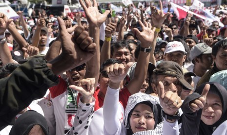 Pendukung pasangan Capres dan Cawapres nomor urut 01, Joko Widodo (Jokowi)-Ma'ruf Amin, berjalan menuju lokasi Konser Putih Bersatu sebagai rangkaian kampanye akbar pasangan capres-cawapres tersebut di Gelora Bung Karno (GBK), Jakarta, Sabtu (13/4).