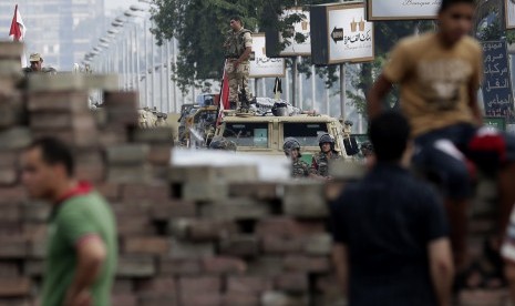   Pendukung Presiden Muhammad Mursi bertahan di depan gedung Pengawal Republik di Nasr City, Kairo, Rabu (10/7).   (AP/Hassan Ammar)