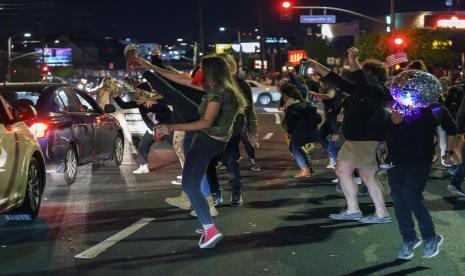  Pendukung Presiden terpilih Joe Biden dan Wakil Presiden terpilih Kamala Harris menari di Sunset Blvd., di Los Angeles Sabtu malam, 7 November 2020. Demokrat Joe Biden mengalahkan Presiden Donald Trump untuk menjadi presiden Amerika Serikat ke-46 pada hari Sabtu , memposisikan dirinya untuk memimpin bangsa yang dicengkeram oleh pandemi bersejarah dan pertemuan gejolak ekonomi dan sosial