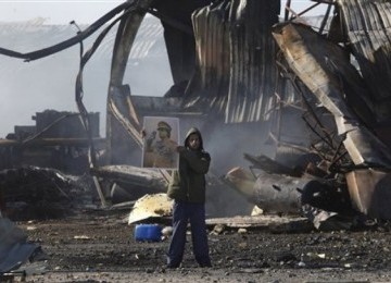 Pendukung Qaddafi di antara puing-puing bekas serangan pasukan koalisi di Tripoli