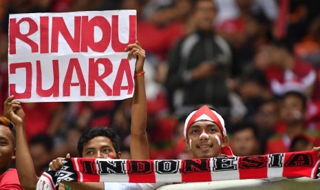 Pendukung tim nasional sepak bola Indonesia meneriakkan semangat ketika menonton pertandingan babak final putaran pertama AFF Suzuki Cup 2016 antara Indonesia dan Thailand di Stadion Pakansari, Cibinong, Kabupaten Bogor, Jawa Barat, Rabu (14/12).