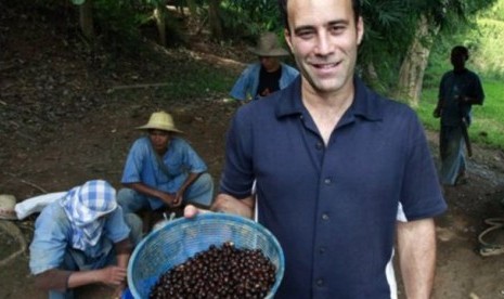 Penemu 'Black Ivory Coffee' atau Kopi Gading Hitam, Blake Dinkin, memegang keranjang berisi biji kopi yang dicampur dengan beberapa buah lainnya untuk memberi makan gajah-gajah di Provinsi Chiang Rai.