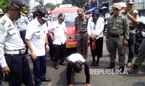 Penertiban parkir liar, seorang sopir angkot, Soni, mendapatkan hukuman push up lantaran tidak mengenakan seragam, Rabu (5/7). 