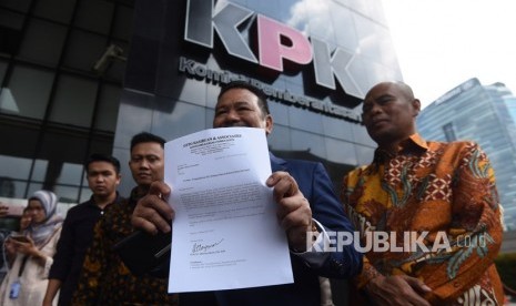 Pengacara Otto Hasibuan (kedua kanan) memperlihatkan surat pengunduran dirinya sebagai kuasa hukum tersangka kasus korupsi KTP Elektronik Setya Novanto saat tiba di gedung KPK, Jakarta, Jumat (8/12).