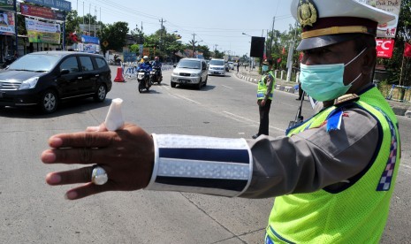 Pengalihan Arus  Balik Pantura. Petugas kepolisian mengalihkan arus lalu lintas di jalur Pantura, Tegal, Jawa Tengah, Selasa (21/7). 