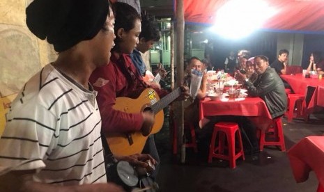 Pengamen menyanyikan lagu hits Ahmad  Dhani dan Dewa di kedia Dudung, Jakarta pusat, (21/1).