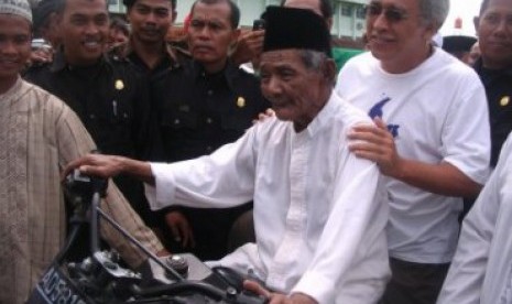 Pengasuh Ponpes Al Muttaqin, KH Muslim Rifai Imampuro atau Mbah Lim memboncengkan Iwan Fals pada rangkaian acara Tour Spiritual bersama dengan Al-Zastrouw dan Grup Musik Ki Ageng Ganjur beberapa waktu lalu. 