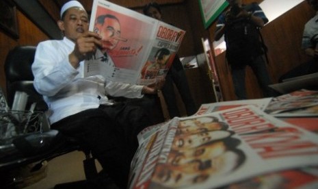 Pengasuh Ponpes Darul Ulum KH Cholil Dahlan membaca tabloid Obor Rakyat di Ponpes Darul Ulum Rejoso Peterongan, Jombang, Jawa Timur, Selasa (3/6). 