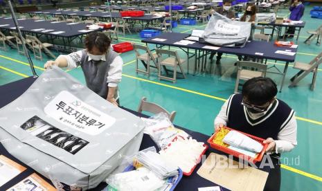 Pengawas pemilihan Korea Selatan memeriksa mesin penghitung suara di sebuah pos penghitungan suara sementara di sebuah stadion di Suwon, selatan Seoul, Korea Selatan, Selasa (14/4). Korea Selatan akan mengadakan pemilihan umum pada 15 April 2020.   