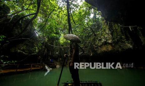 Pengelola wisata Rosyadi menggunakan rakit bambu di Geotourism Geopark Meratus Goa Limbuhang Haliau di Desa Haliau, Kabupaten Hulu Sungai Tengah, Kalimantan Selatan, Rabu (29/12/2021). Wisata alam yang dikelola oleh Pokdarwis Mancakup itu menjadi salah satu dari 34 situs warisan geologi yang diusulkan oleh badan pengelola Geopark Meratus ke UNESCO Global Geopark (UGG).