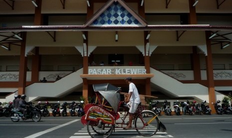 Pengemudi becak melintas di depan bangunan baru Pasar Klewer sisi barat di Solo, Jawa Tengah, Minggu (23/4). 