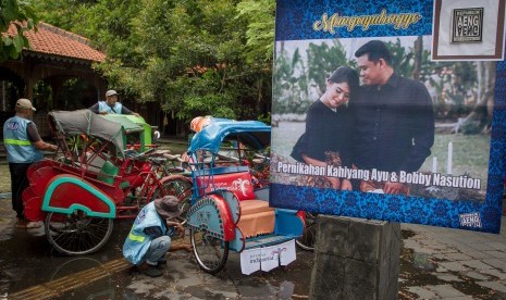 Pengemudi becak mencuci becak yang akan digunakan untuk mengantar tamu undangan pernikahan Kahiyang Ayu dan Bobby Nasution di Ngarsopuro, Solo, Jawa Tengah, Jumat (3/11).