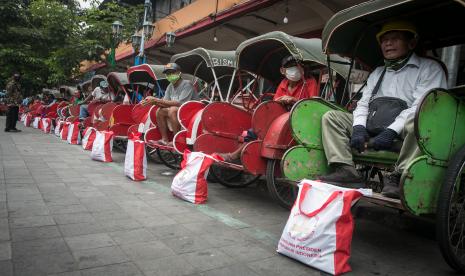 Pengemudi becak menerima bantuan dari Presiden Joko Widodo usai kegiatan kunjungan dan membagikan Bantuan Langsung Tunai (BLT) minyak goreng di Pasar Gede, Solo, Jawa Tengah, Kamis (26/5/2022). Usai menjadi wali nikah adiknya Idayati dengan Ketua MK Anwar Usman, Presiden Joko Widodo melakukan kunjungan dan membagikan bantuan langsung tunai (BLT) kepada masyarakat di Pasar Gede, Pasar Mojosongo, Pasar Harjodaksino dan Taman Balekambang.