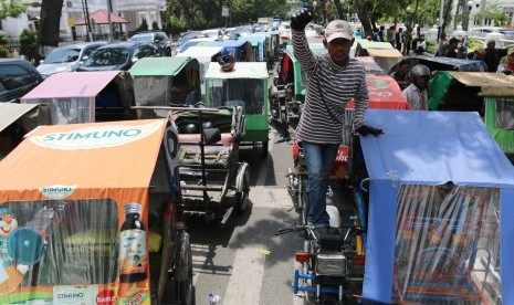 Pengemudi becak motor berada di dekat kendaraan mereka saat mogok beroperasi, di depan Kantor Gubernur Sumatera Utara, di Medan, Selasa (24/10). Aksi serupa terjadi di beberapa daerah termasuk di Makassar, Sulsel pada hari ini.