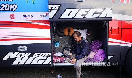 Pengemudi bus program Mudik Bareng IndiHome 2019 menunggu keberangkatan di dalam kabin bus yang menjadi kamarnya di Lapang Aldiron  Jakarta, Sabtu (1/6).