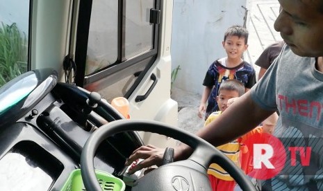 Pengemudi bus sedang memasan perangkat klakson khusus (Telolet) di busnya