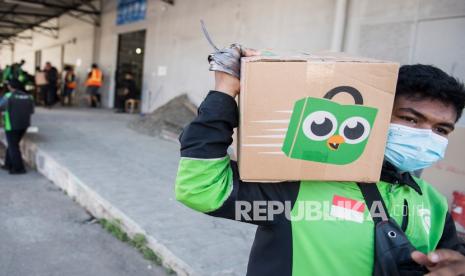 Pengemudi daring Gojek membawa kemasan paket dari Tokopedia di Titipaja Warehouse, Jakarta.  Mobilitas masyarakat dinilai mulai kembali pulih setelah aturan Pemberlakukan Pembatasan Kegiatan Masyarakat (PPKM) dilonggarkan. Head of Global Marketing Transport Gojek Amanda Parikesit mengakui mobilitas masyarakat sempat terbatas selama pandemi. 