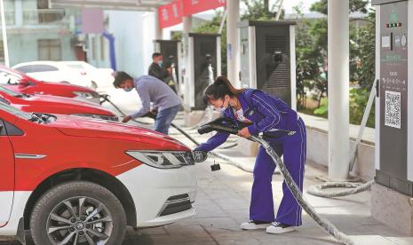 Pengemudi mengisi daya kendaraan listrik mereka di fasilitas pengisian daya di Tongren, Provinsi Guizhou.