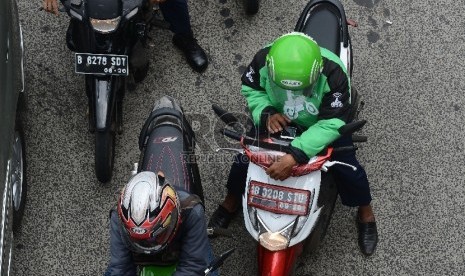  Pengemudi ojek online melintasi Jalan Rasuna Said, Jakarta Selatan, Jumat (18/12).