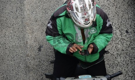  Pengemudi ojek online melintasi Jalan Rasuna Said, Jakarta Selatan, Jumat (18/12).