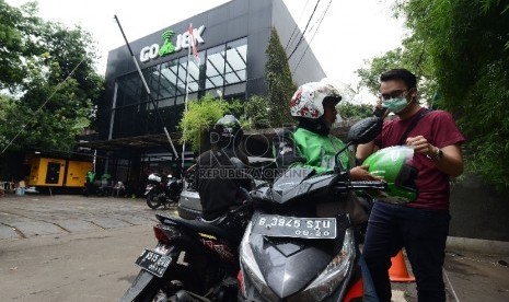  Pengemudi ojek online mengangkut penumpang di Jalan Kemang Selatan, Jakarta, Jumat (18/12). 