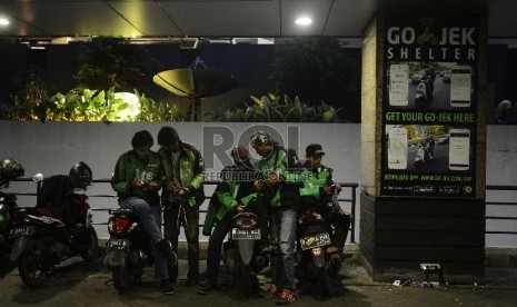   Pengemudi ojek online menunggu penumpang di Kawasan Sudirman, Jakarta Selatan, Jumat (18/12). 