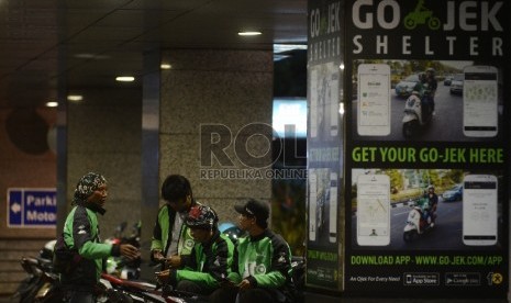  Pengemudi ojek online menunggu penumpang di Kawasan Sudirman, Jakarta Selatan, Jumat (18/12).