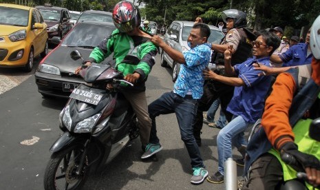 Pengemudi taksi terlibat ricuh dengan pengemudi gojek yang melintas saat unjuk rasa menolak operasi Go-jek di Balaikota Solo, Jawa Tengah, Rabu (15/3).