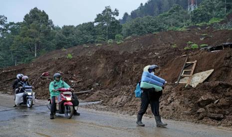 Pengendara melewati jalan yang terkena dampak tanah longsor akibat gempa di Cianjur, Jawa Barat, Indonesia, Rabu, 23 November 2022. 