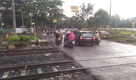 Pengendara melewati palang pintu di pertigaan di samping Stasiun Cakung, Jakarta Timur