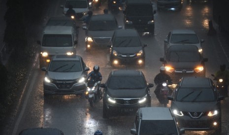 Pengendara meliintasi hujan di kawasan Gatot Subroto, Jakarta, Senin (11/2/2019).